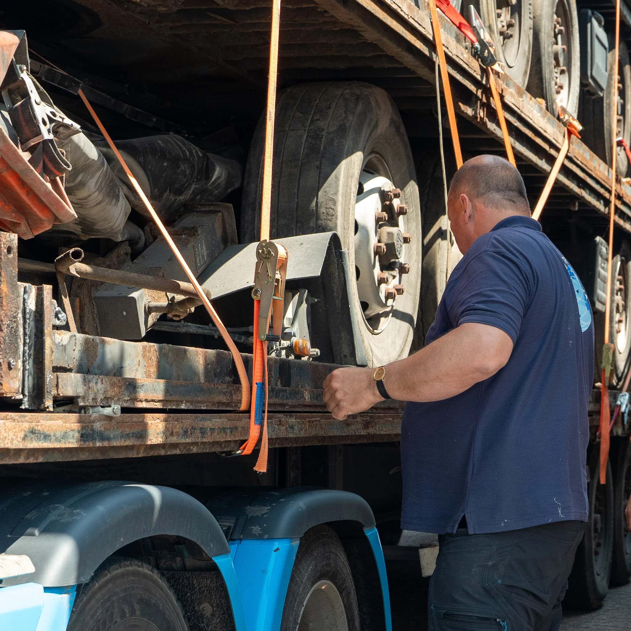 Mostert Scrap medewerker laadt metalen schroot op een vrachtwagen op het terrein.